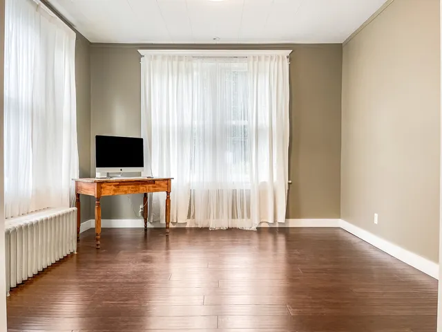 a view of room with wooden floor and windows