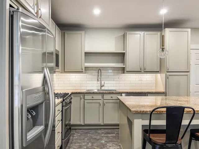 a kitchen with stainless steel appliances granite countertop a sink stove and refrigerator