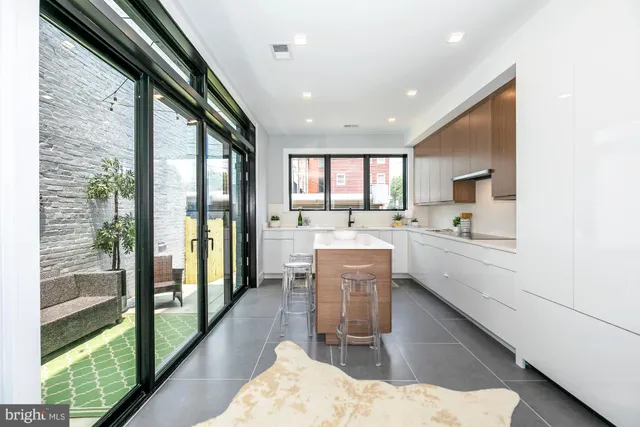 a dining hall with stainless steel appliances kitchen island granite countertop a refrigerator and a sink