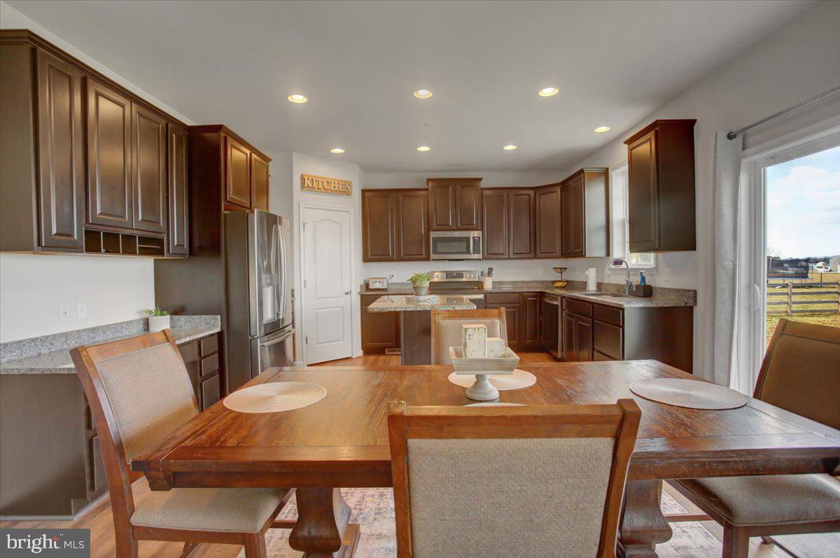 9822 Ripple Drive Williamsport, MD 21795 - Photo 10 of 41 a kitchen with stainless steel appliances granite countertop a refrigerator a stove top oven a sink a dining table and chairs