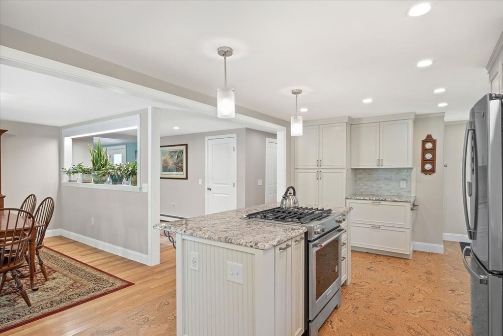 7 Brook Street Plympton, MA 02367 - Photo 8 of 42 a kitchen with a stove a refrigerator a sink a dining table and chairs with wooden floor