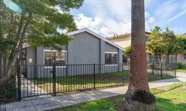 a view of a house with a backyard and a tree