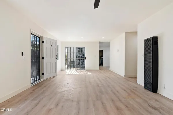 a view of empty room with wooden floor