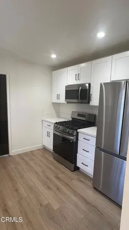 a kitchen with granite countertop a refrigerator stove and sink