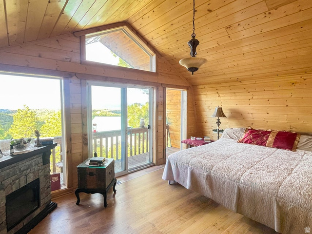 2498 West Silverado Ridge Alton, UT 84710 - Photo 15 of 51 Bedroom with wood walls, wooden ceiling, light wood-style flooring, a fireplace, and access to outside