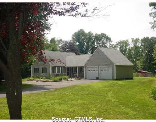 a front view of a house with a garden and trees