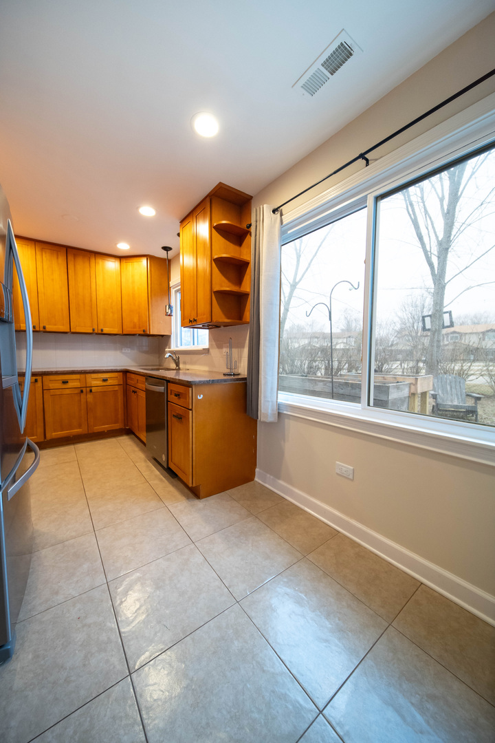 1504 Chippewa Trail Wheeling, IL 60090 - Photo 10 of 28 a kitchen with stainless steel appliances kitchen island granite countertop a refrigerator and a sink
