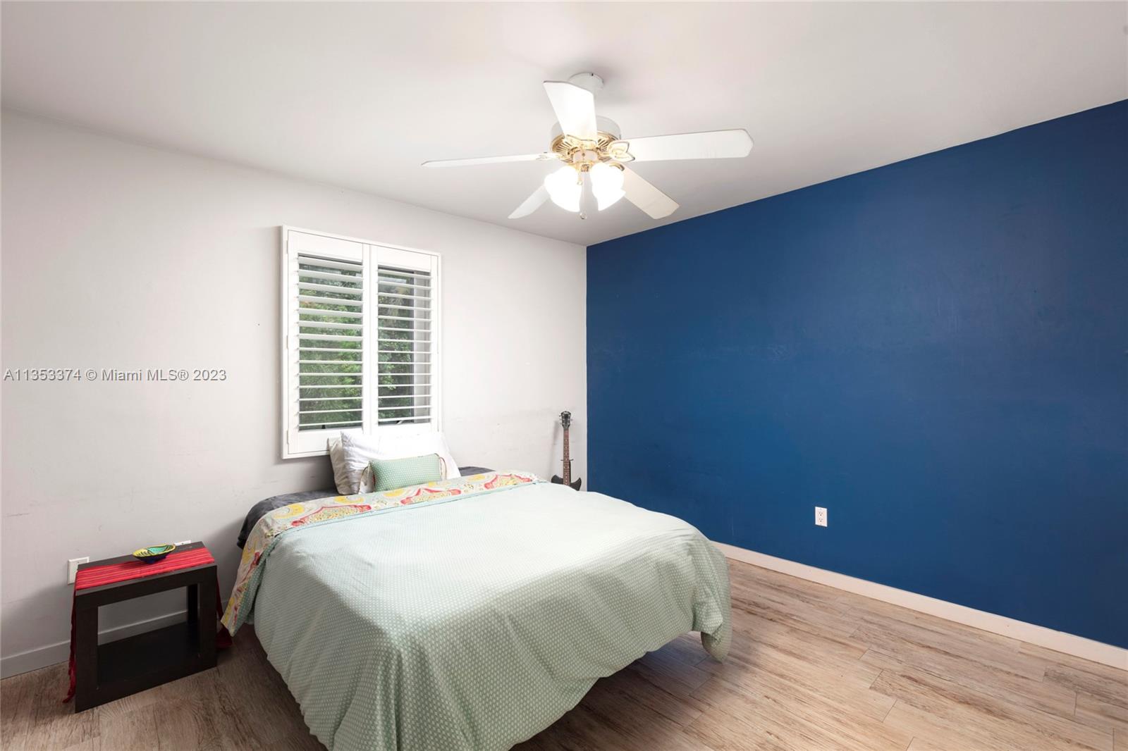 6745 Southwest 94th Street Pinecrest, FL 33156 - Photo 12 of 24 a bedroom with a bed and a chandelier