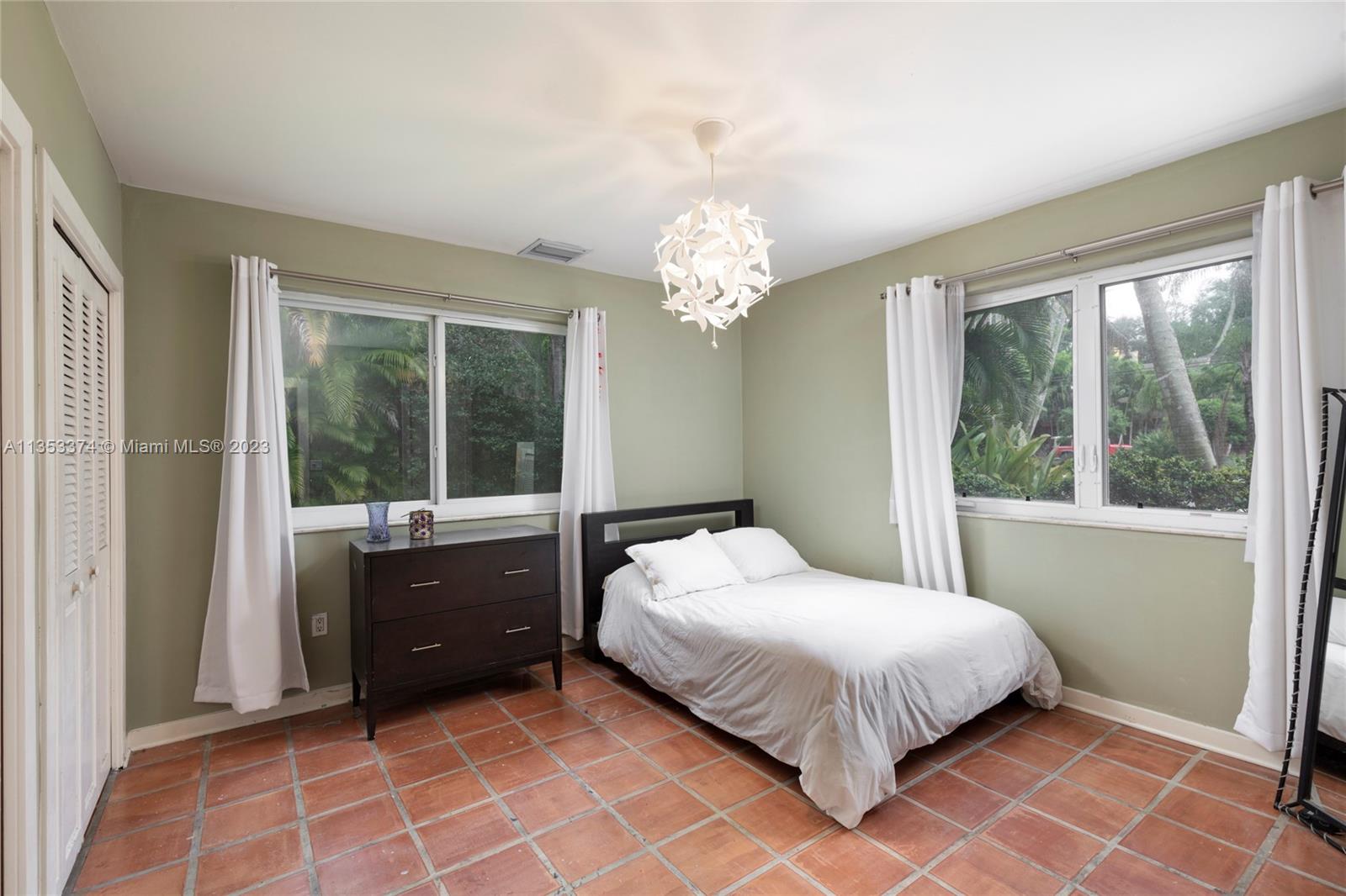 6745 Southwest 94th Street Pinecrest, FL 33156 - Photo 15 of 24 a bedroom with a large bed and a window