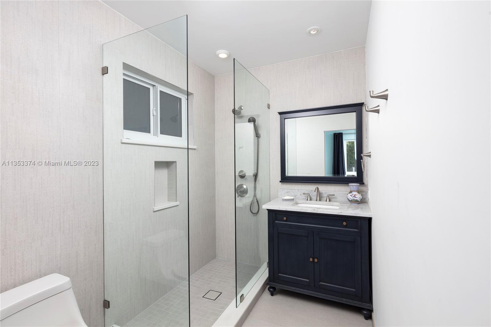 6745 Southwest 94th Street Pinecrest, FL 33156 - Photo 16 of 24 a bathroom with a sink a mirror and a shower