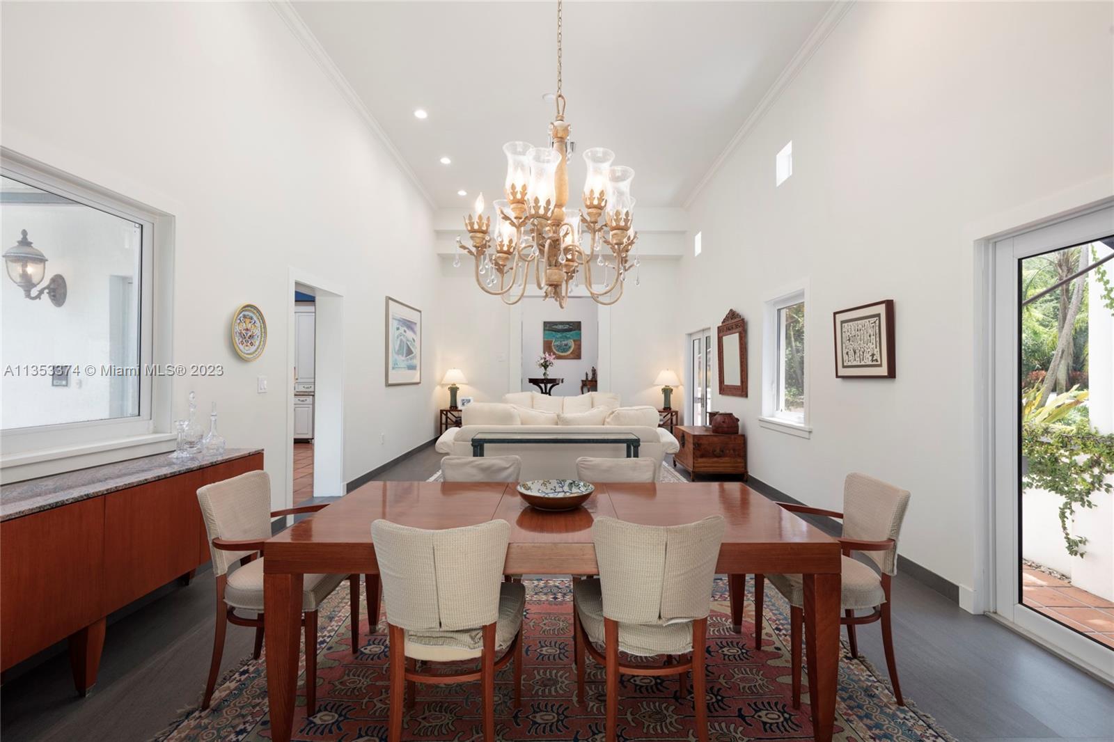 6745 Southwest 94th Street Pinecrest, FL 33156 - Photo 3 of 24 a view of a dining room with furniture a chandelier and wooden floor