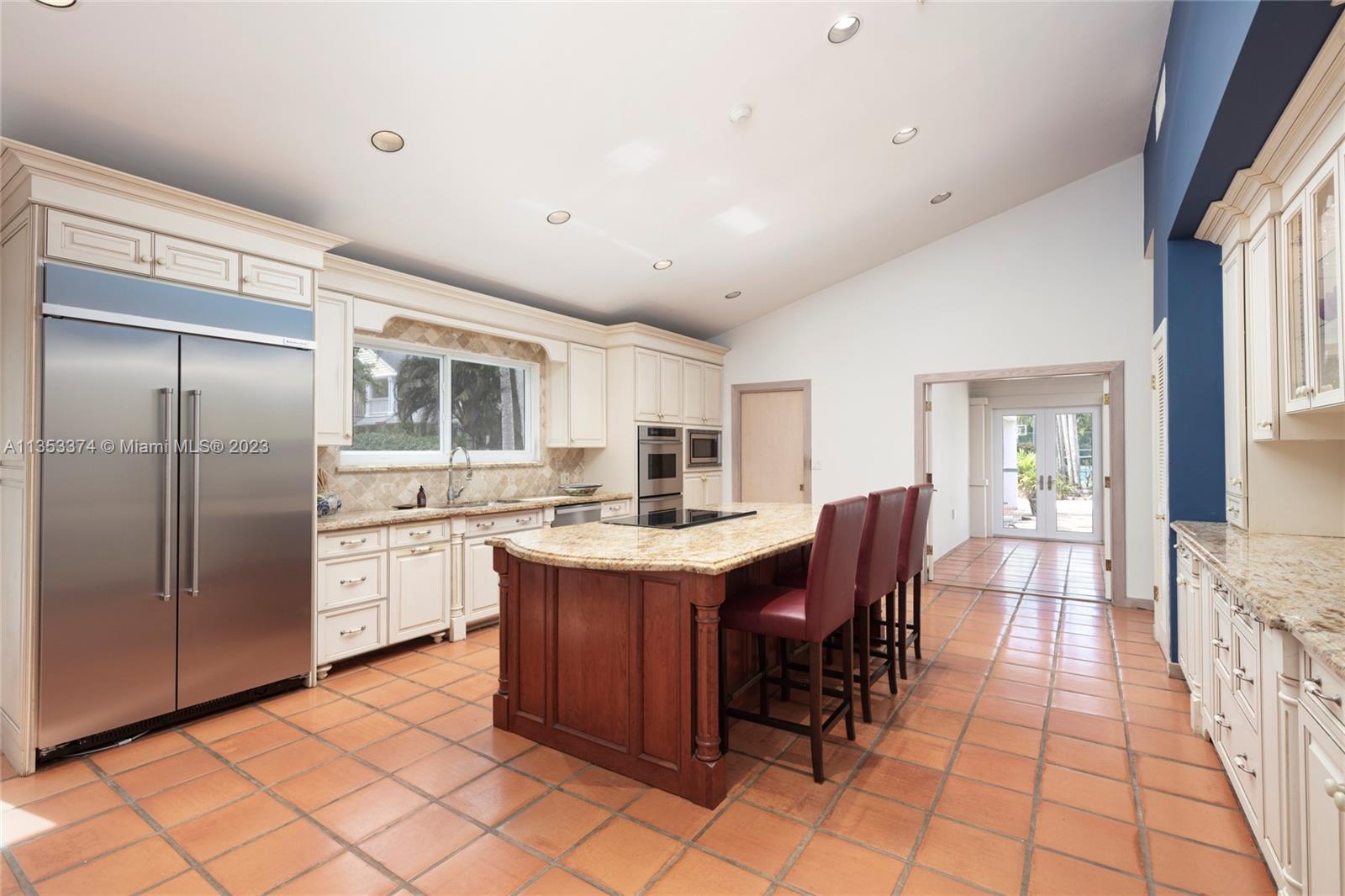 6745 Southwest 94th Street Pinecrest, FL 33156 - Photo 5 of 24 a large white kitchen with a large window and stainless steel appliances