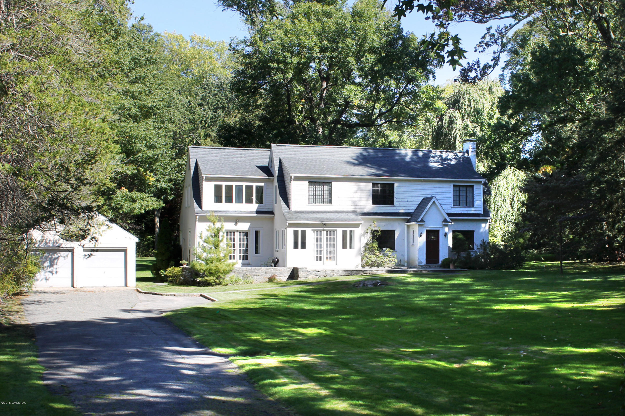 32 Gilliam Lane Riverside, CT 06878 - Photo 1 of 4 a front view of a house with a garden and trees