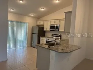 a kitchen with stainless steel appliances granite countertop a sink refrigerator and microwave