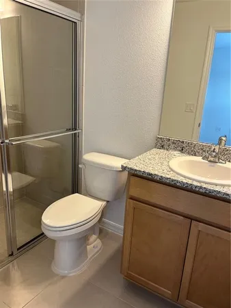 a bathroom with a granite countertop toilet and a sink