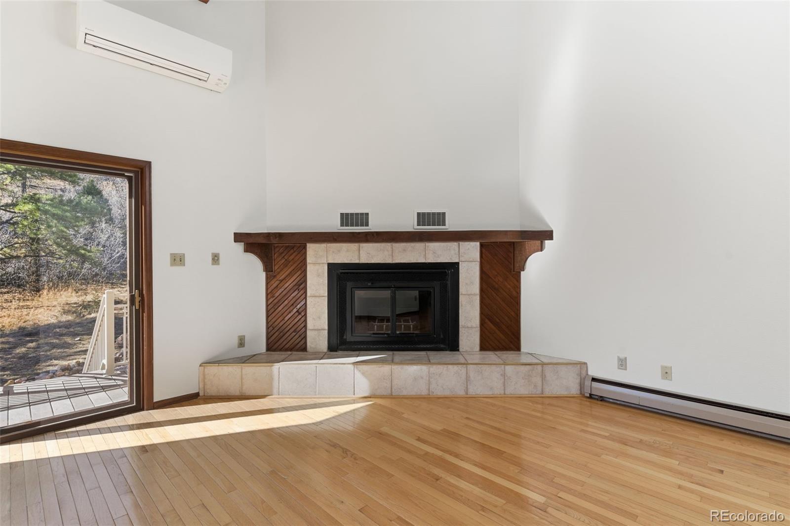 485 West Woodmen Road Colorado Springs, CO 80919 - Photo 17 of 50 a view of empty room with wooden floor and a fireplace