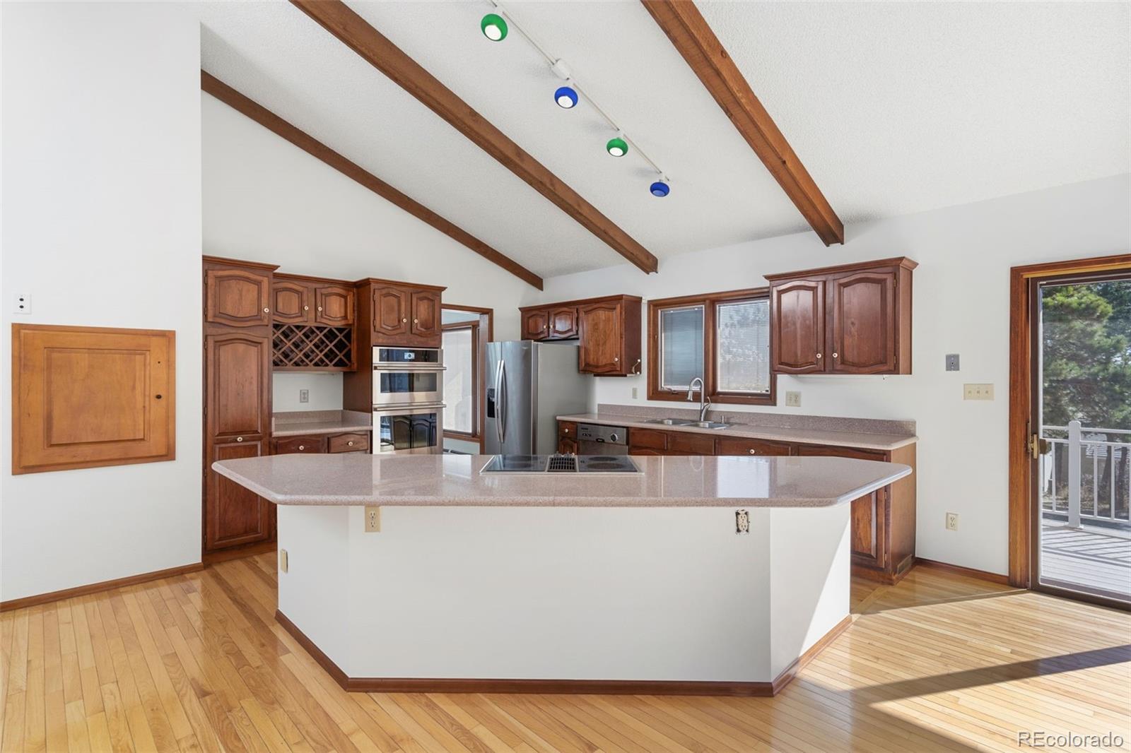485 West Woodmen Road Colorado Springs, CO 80919 - Photo 23 of 50 a large living room with stainless steel appliances granite countertop a couch a dining table and chairs with wooden floor