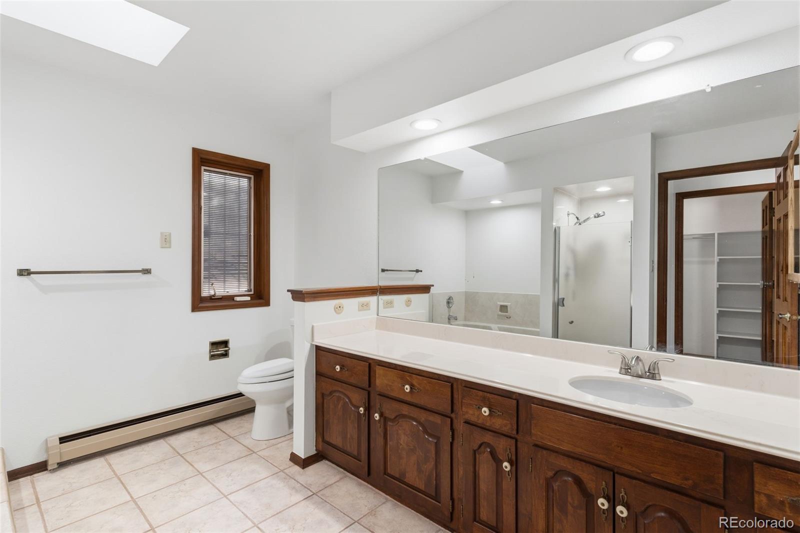 485 West Woodmen Road Colorado Springs, CO 80919 - Photo 27 of 50 a spacious bathroom with a double vanity sink a toilet mirror and a