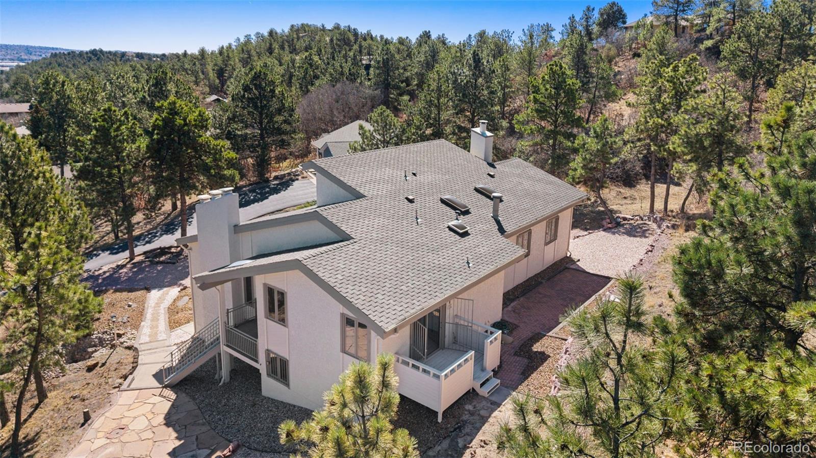 485 West Woodmen Road Colorado Springs, CO 80919 - Photo 3 of 50 an aerial view of a house with a mountain and trees in the background