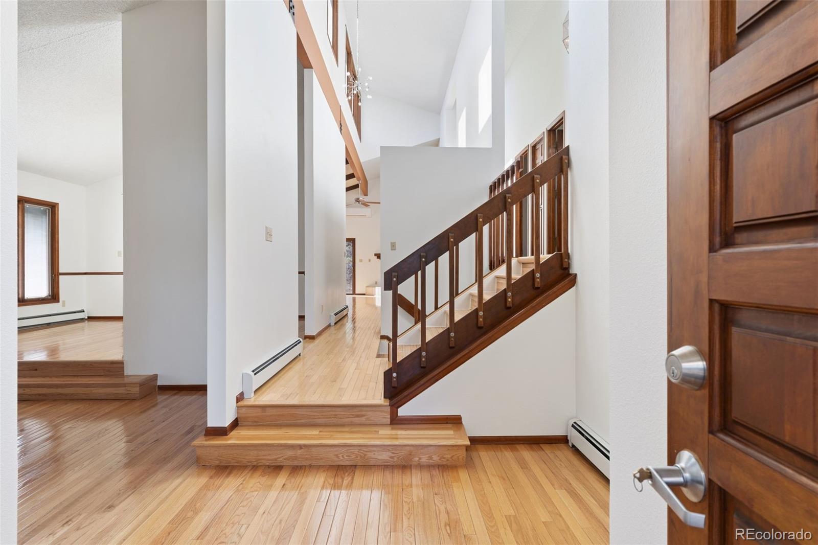 485 West Woodmen Road Colorado Springs, CO 80919 - Photo 8 of 50 a view of entryway with wooden floor and stairs