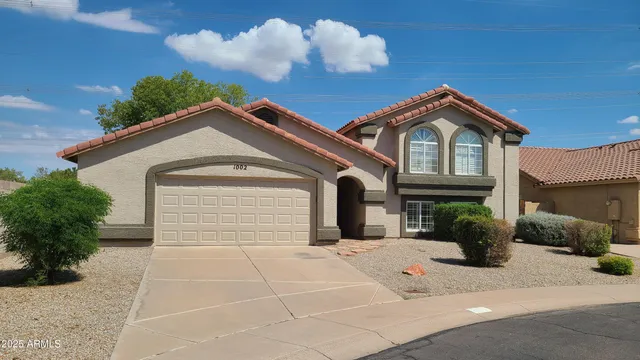 a living room with couches and kitchen view with wooden floor