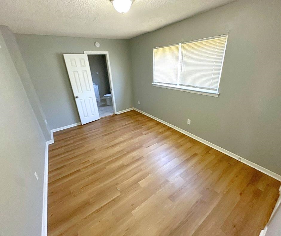 3747 Parakeet Road Memphis, TN 38109 - Photo 3 of 9 Empty room featuring light wood-type flooring and a textured ceiling