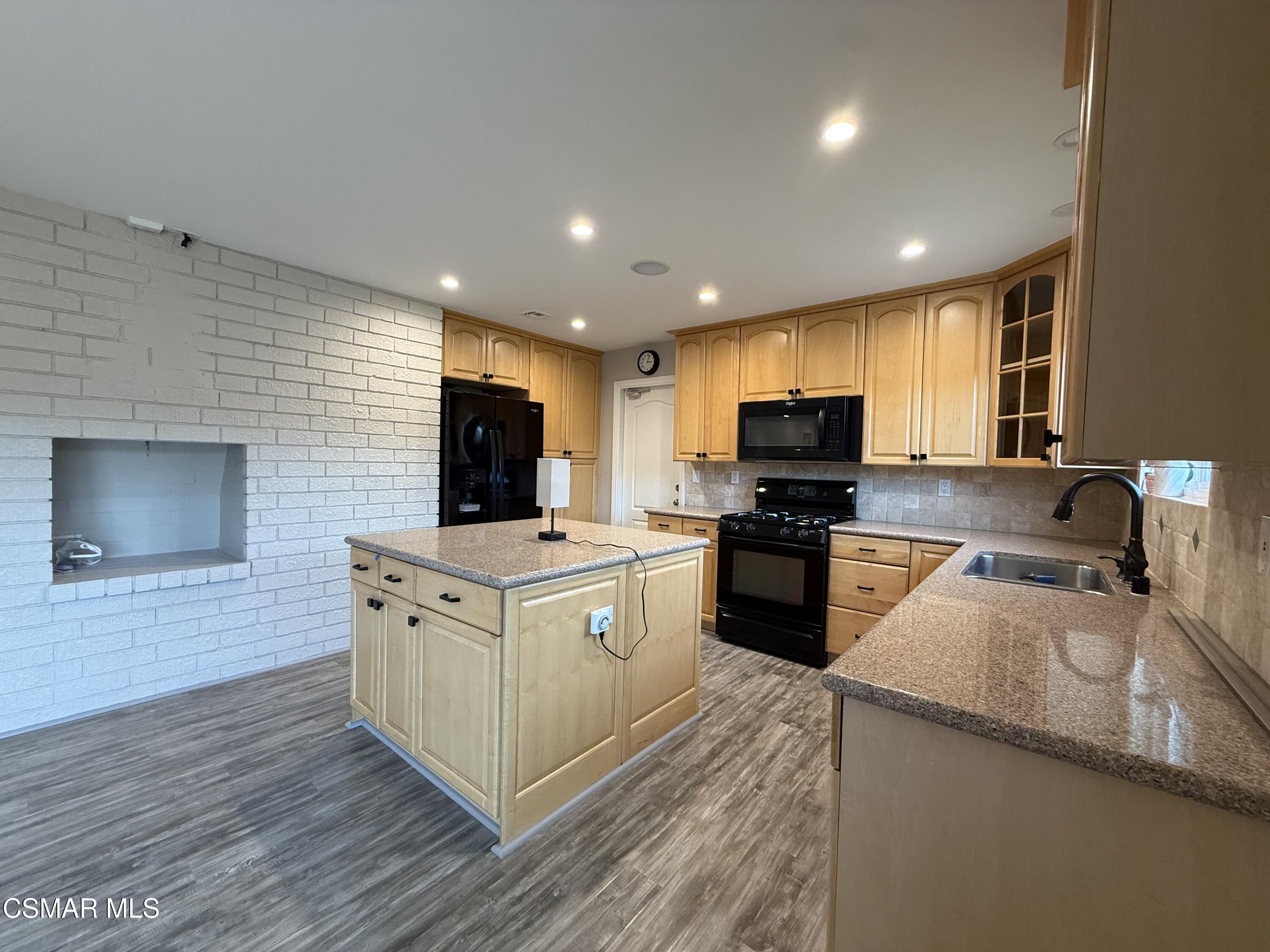 3446 Travis Avenue Simi Valley, CA 93063 - Photo 17 of 36 a kitchen with granite countertop a stove top oven a sink dishwasher and a refrigerator with wooden floor