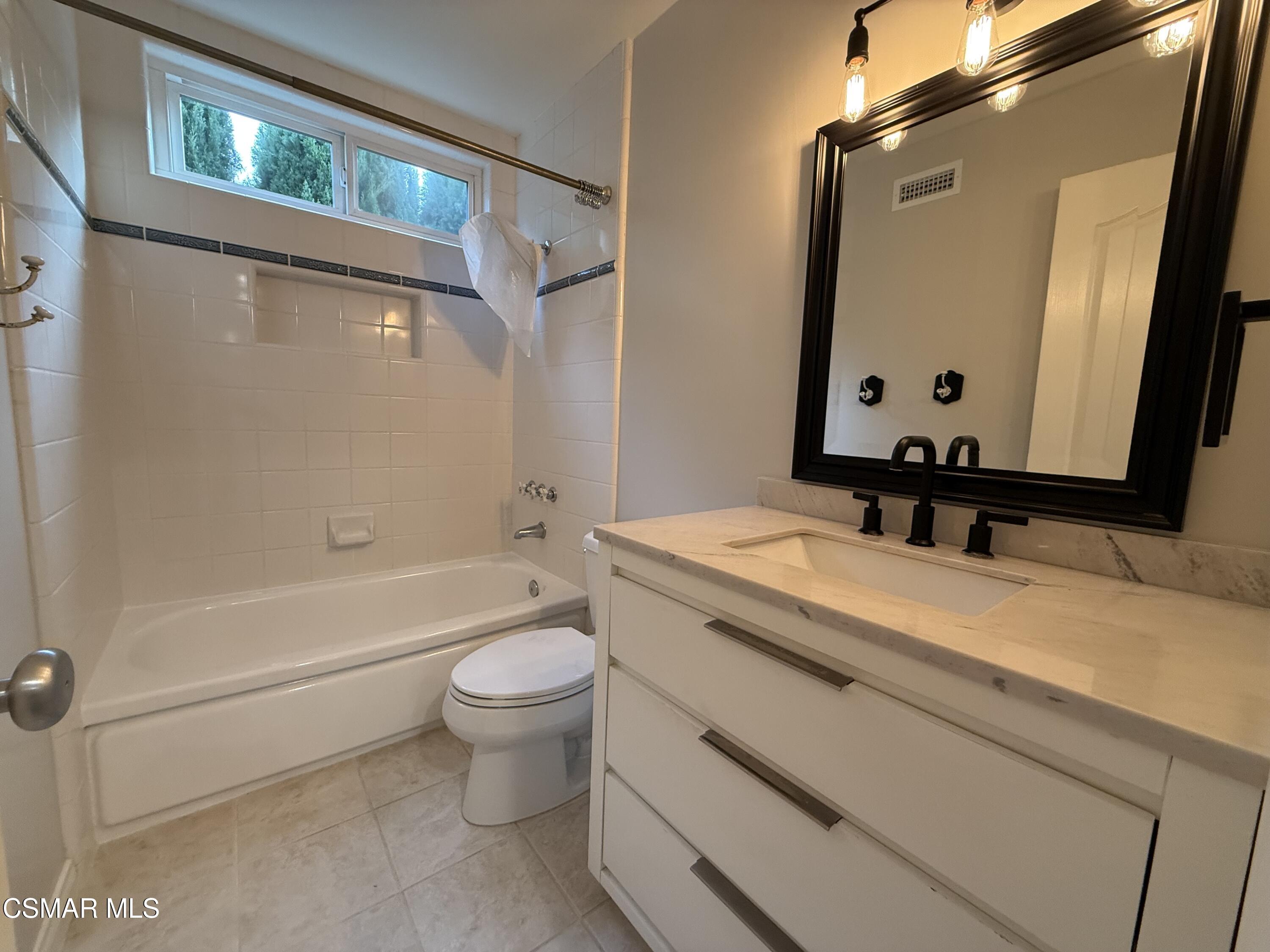 3446 Travis Avenue Simi Valley, CA 93063 - Photo 27 of 36 a bathroom with a granite countertop sink a toilet and a bathtub