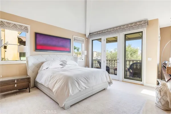 a large bed sitting in a bedroom next to a window