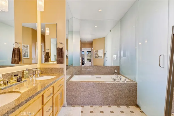 a bathroom with a tub sink and mirror