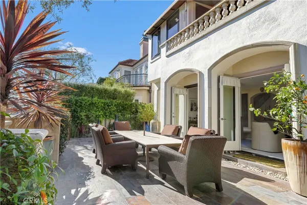 a view of a patio with couches table and chairs and potted plants