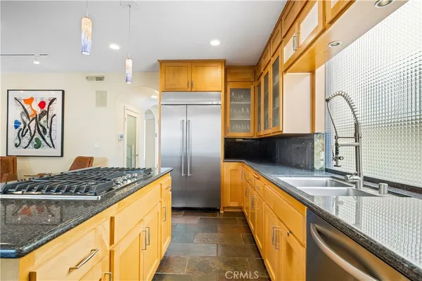 a kitchen with stainless steel appliances granite countertop a sink and a refrigerator
