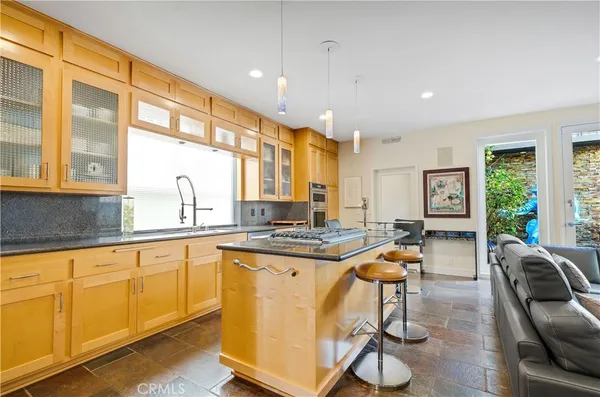 a living room with stainless steel appliances granite countertop furniture and a kitchen view