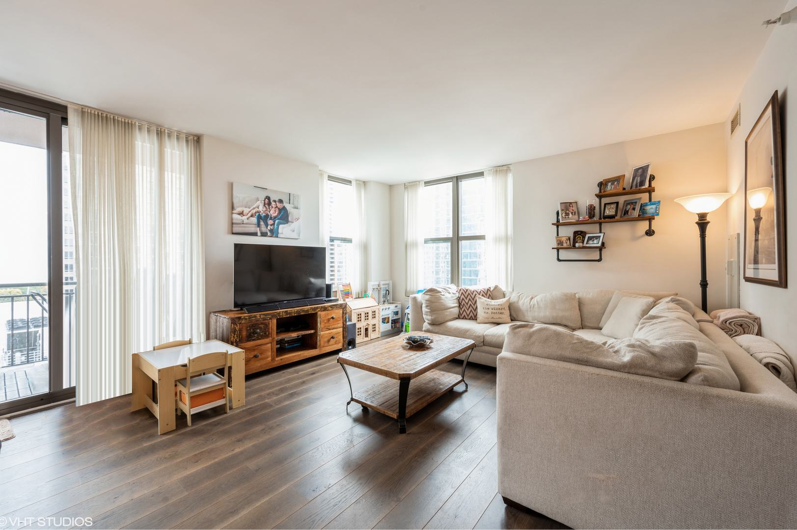 1101 South State Street, Unit H1504 Chicago, IL 60605 - Photo 2 of 16 a living room with furniture and a flat screen tv
