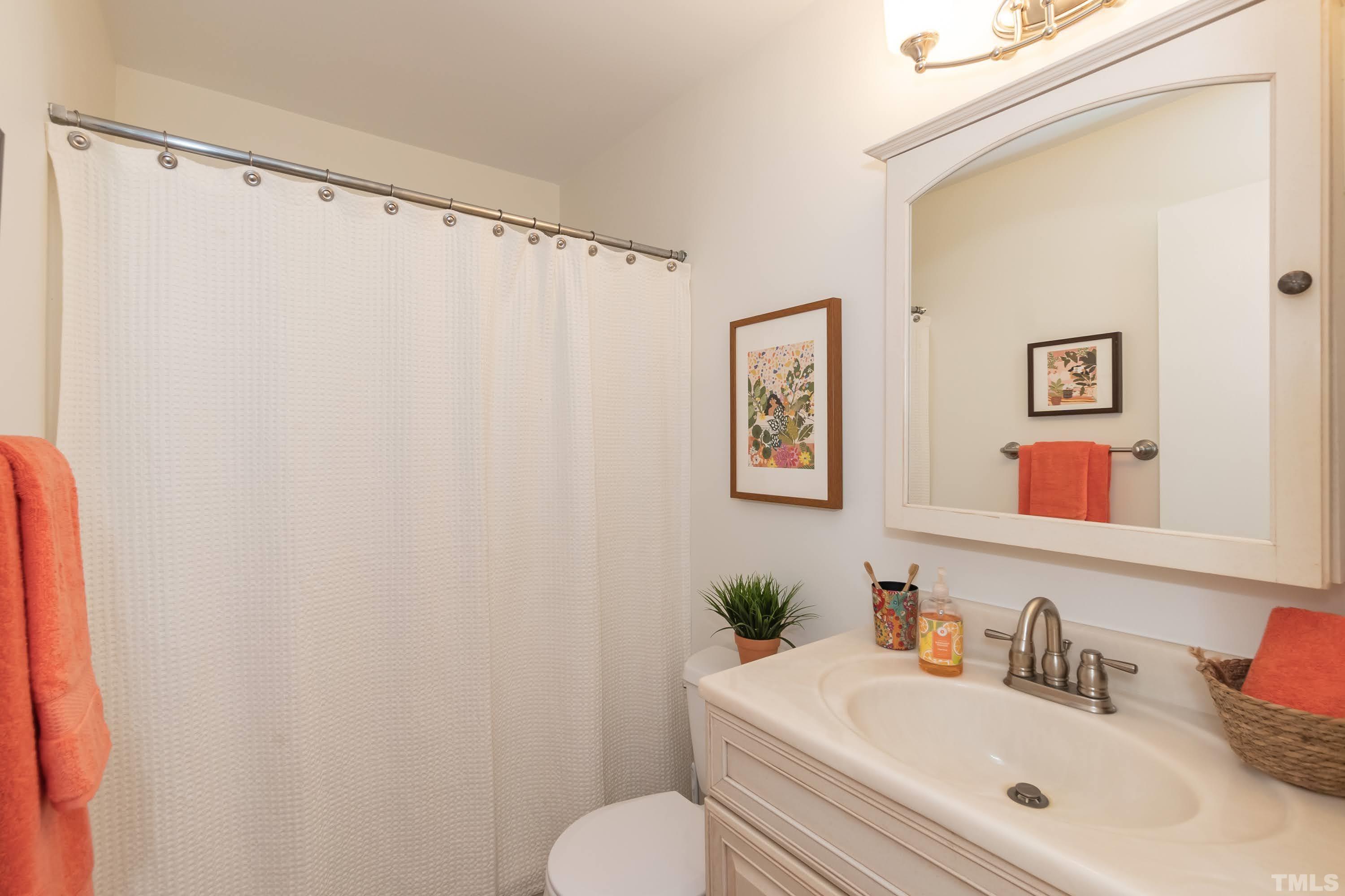 1720 Bennett Street Raleigh, NC 27604 - Photo 15 of 46 a bathroom with a sink mirror vanity and toilet