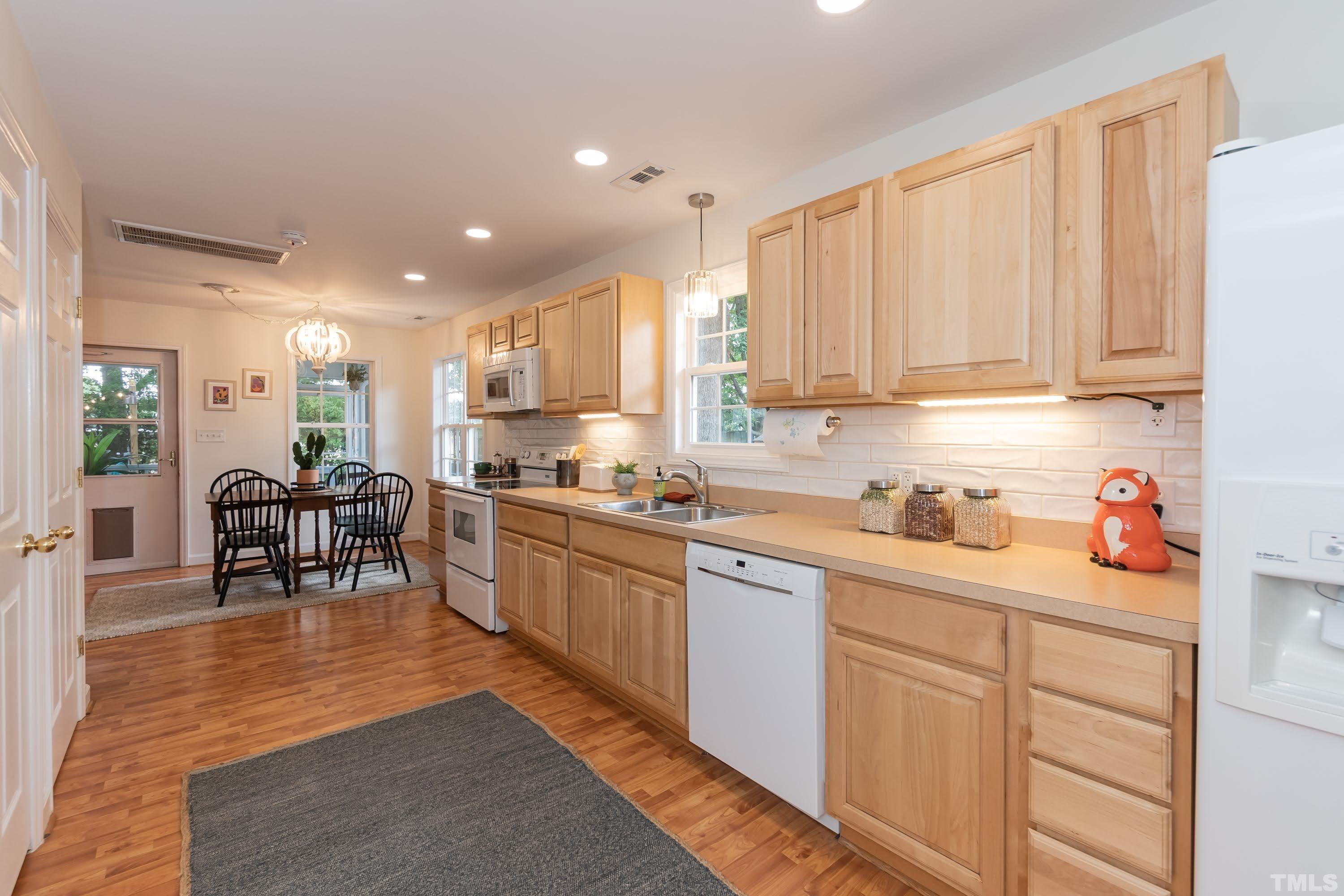 1720 Bennett Street Raleigh, NC 27604 - Photo 17 of 46 a kitchen with stainless steel appliances granite countertop sink stove refrigerator and cabinets