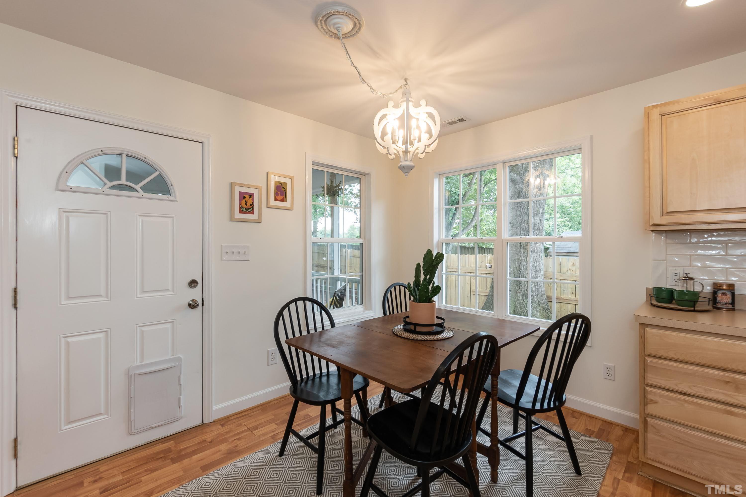 1720 Bennett Street Raleigh, NC 27604 - Photo 19 of 46 a view of a dining room with furniture a chandelier and wooden floor