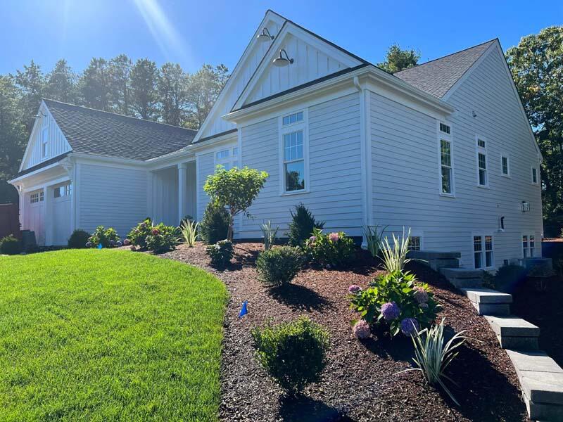 55 Palmer Road Mashpee, MA 02649 - Photo 3 of 42 a front view of a house with a yard and potted plants