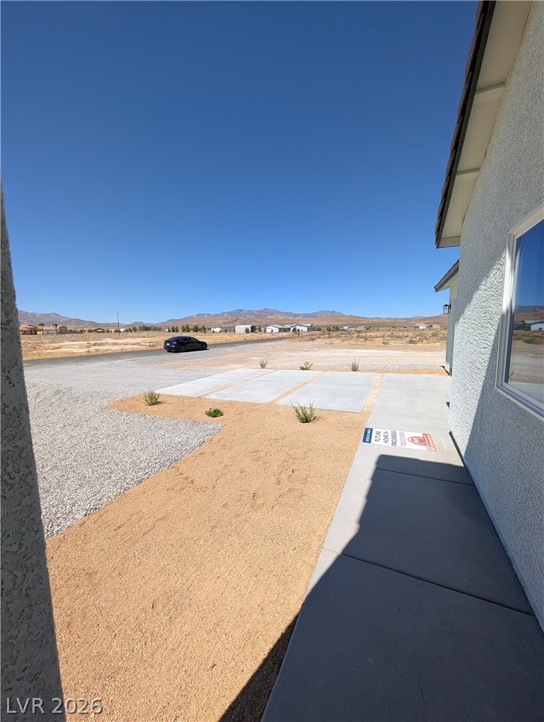 4670 Medicine Man Road Pahrump, NV 89048 - Photo 35 of 36 A newly landscaped front yard with minimalist desert plantings leads to a desert and mountain vista.