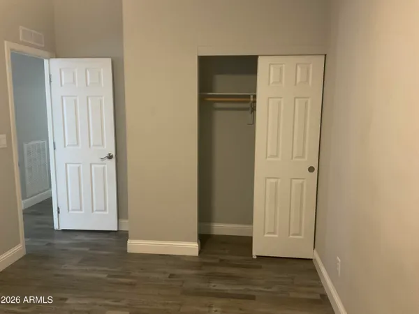 an empty room with wooden floor and a bathroom