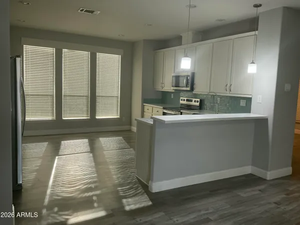 a kitchen with granite countertop white cabinets and stainless steel appliances