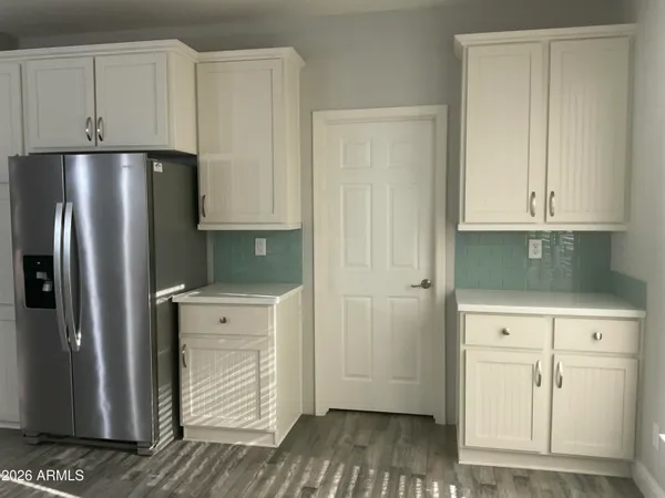 an empty room with wooden floor and closet area
