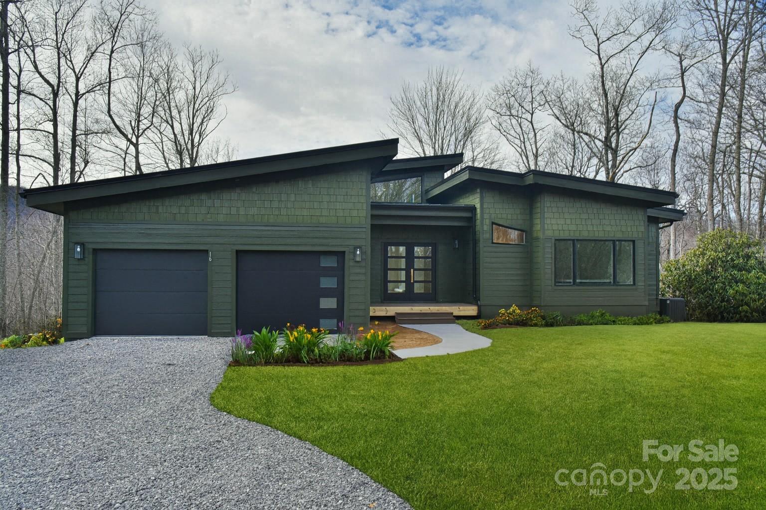 a front view of a house with a garden and yard