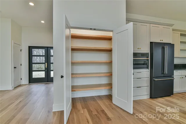 a bedroom with a large bed and wooden floor