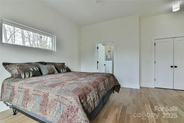 a bedroom with a bed and wooden floor