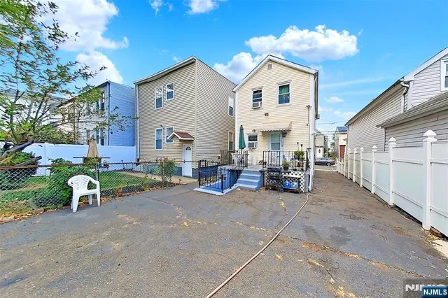 a view of a white house with a large space and a yard