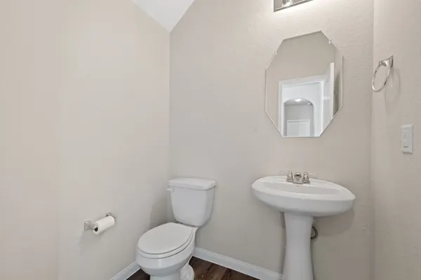 a bathroom with a toilet a sink and mirror