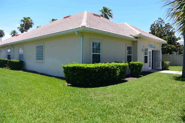 a backyard of a house with plants and tree s