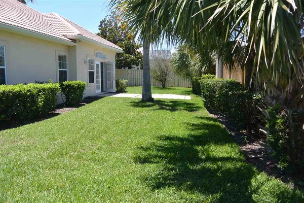 a view of a house with a yard and potted plants
