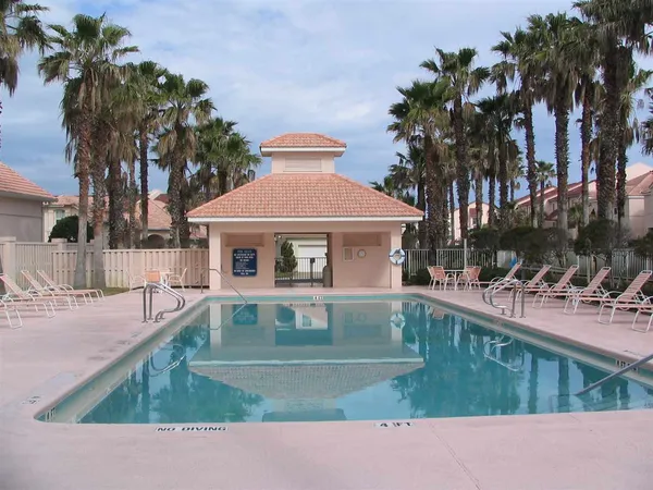 a view of an house with swimming pool lawn chairs and a yard